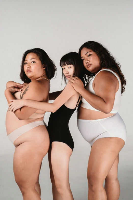 a group of three women standing next to each other, inspired by Vanessa Beecroft, unsplash, big stomach, half asian, wearing leotard, thick linings