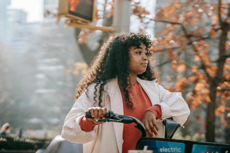 a woman riding a bicycle on a city street, trending on pexels, happening, electric hair, avatar image, brown curly hair, sydney park