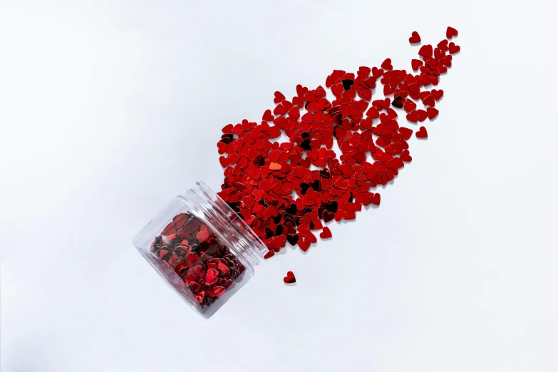 a jar filled with red hearts sitting on top of a white surface, an album cover, by Julia Pishtar, pexels, visual art, made of nanomaterials, like small pieces, 5k, red and black color palette