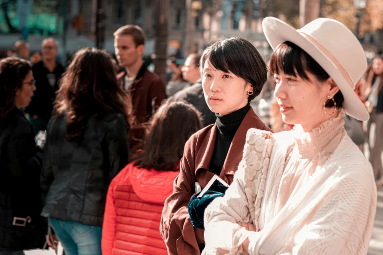 a couple of women standing next to each other on a street, pexels contest winner, james jean and yoji shinkawa, audience, wearing 1890s era clothes, cold sunny weather