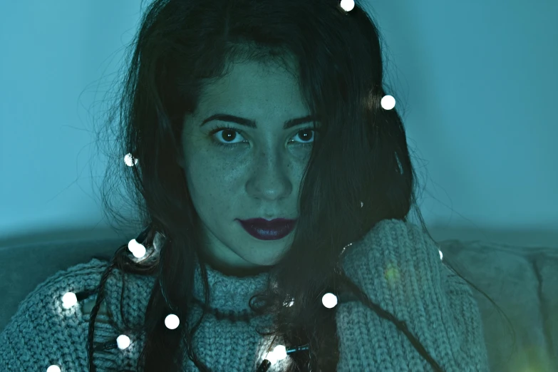 a woman sitting on a couch looking at a cell phone, an album cover, inspired by Elsa Bleda, pexels contest winner, serial art, eyes are glowing red lightbulbs, oona chaplin, christmas night, pale-skinned persian girl