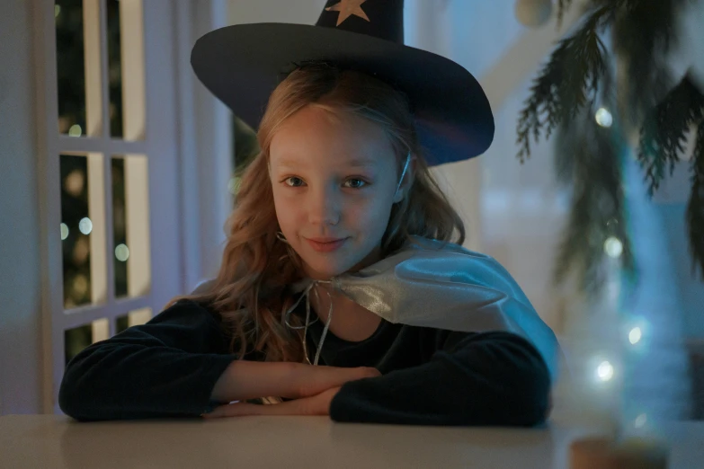 a little girl wearing a witches hat sitting at a table, pexels, christmas night, avatar image, super high resolution, wearing a fancy dress