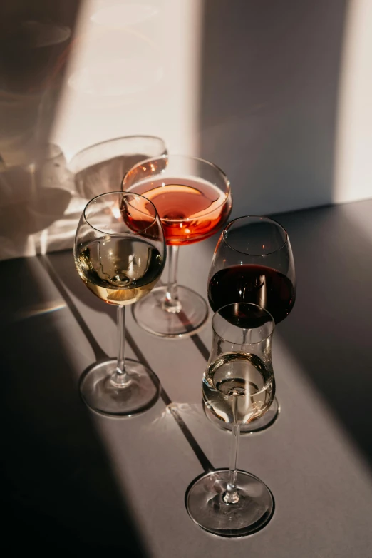 a group of wine glasses sitting on top of a table, afternoon light, curated collections, chromatic, trio