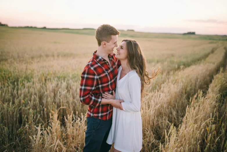 a couple standing in a wheat field at sunset, pexels contest winner, happening, flirting smiling, sydney hanson, modelling, white