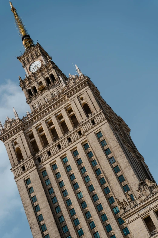 a tall building with a clock on the top of it, a picture, inspired by Leon Wyczółkowski, pexels contest winner, socialist realism, square, brown, panorama, b - roll