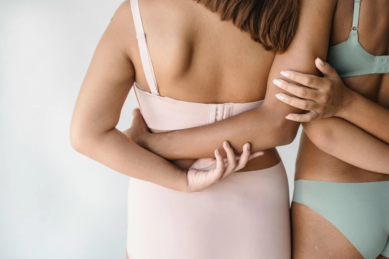 a couple of women standing next to each other, by Emma Andijewska, trending on pexels, renaissance, covered in pink flesh, posing together in bra, manuka, elegant up to the elbow