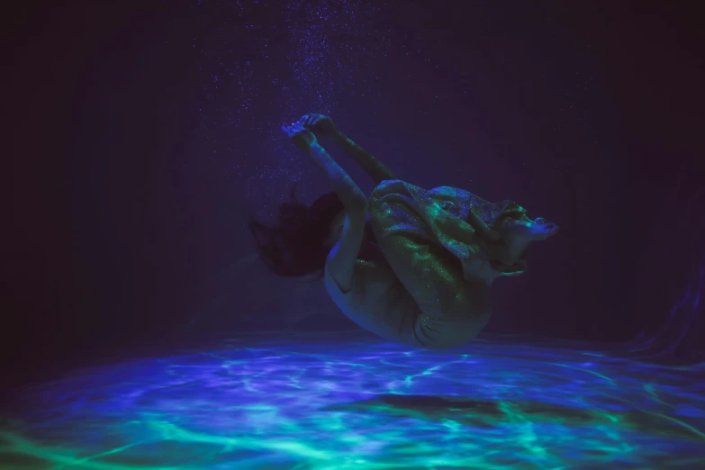 a woman dives under water in a pool, a hologram, inspired by Elsa Bleda, unsplash contest winner, conceptual art, dark blue neon light, float, deep dark purple waters, kristen bell as a mermaid