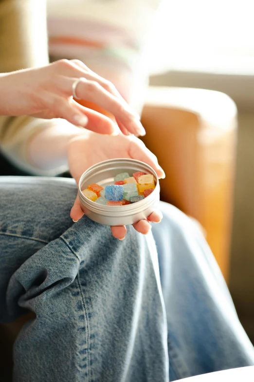 a person sitting on a couch holding a bowl of cereal, process art, gummy candies, metal lid, 65mm, denim