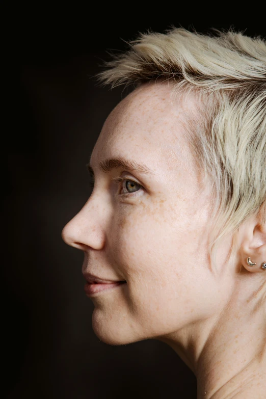 a close up of a person with a cell phone, a character portrait, inspired by Ellen Gallagher, trending on unsplash, photorealism, short platinum hair tomboy, light lighting side view, 40 years old women, pearl earring