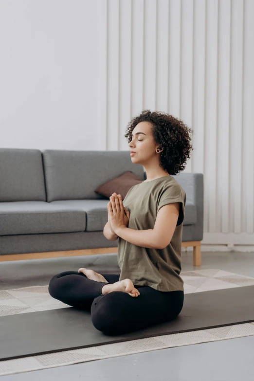 a woman sitting on a yoga mat in a living room, pexels contest winner, renaissance, praying posture, square, plain background, 4k'