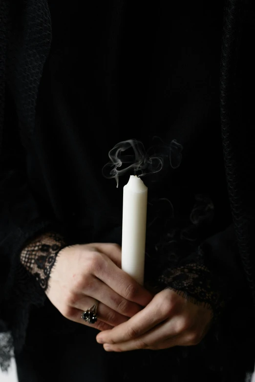 a person holding a candle with smoke coming out of it, a pale skin, dark. no text, ignant, gothic influence