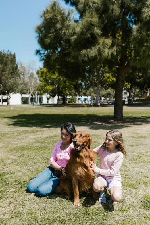 two girls sitting in the grass with a dog, a portrait, by Gavin Hamilton, pexels contest winner, southern california, with a park in the back ground, pink, in a square