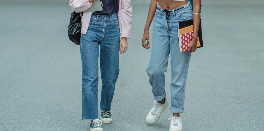a couple of women walking down a street, trending on pexels, baggy jeans, style of stranger things, schools, close-up photo