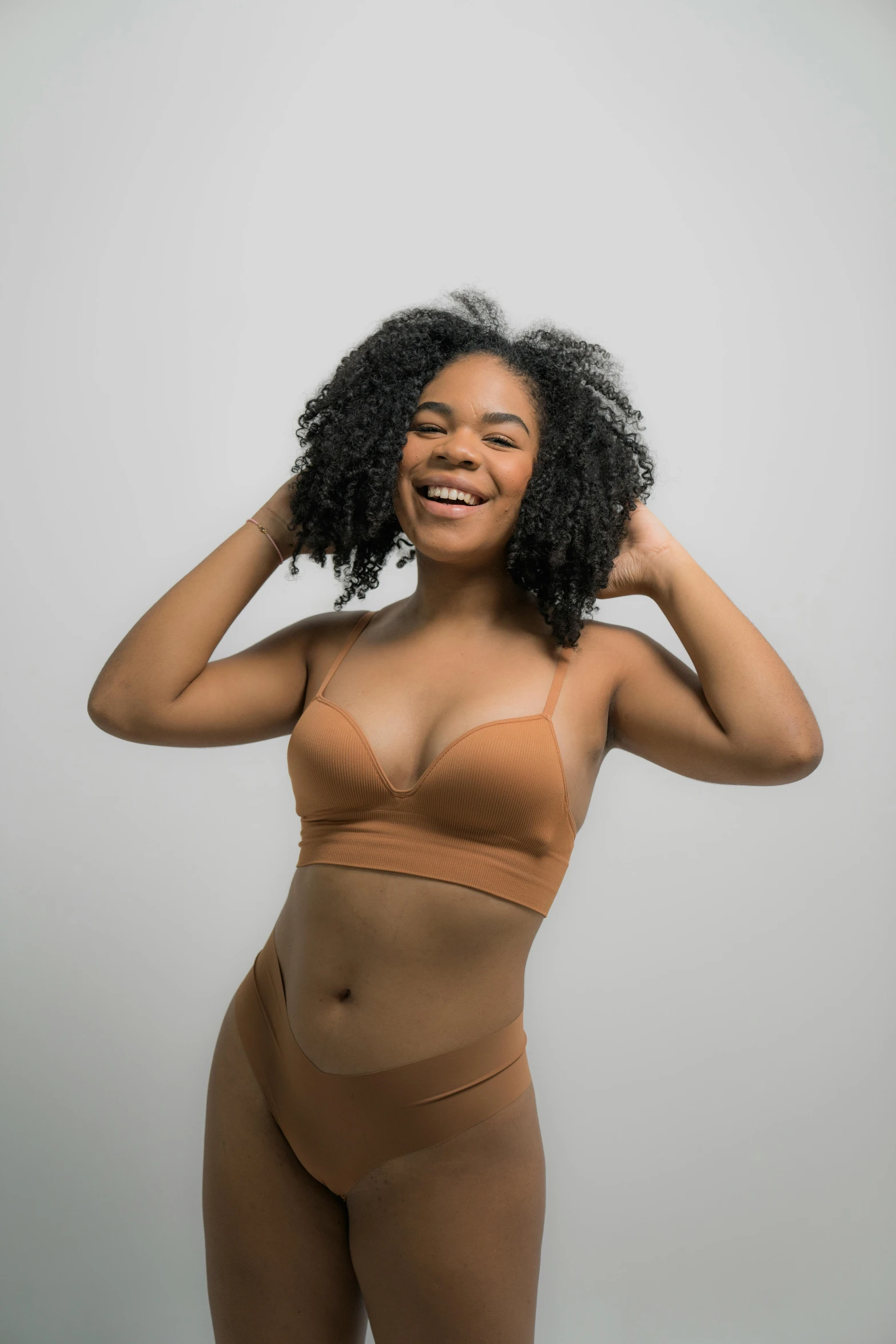 a woman in a bikini posing for a picture, inspired by Daphne Allen, afro tech, light brown, full product shot, posing together in bra