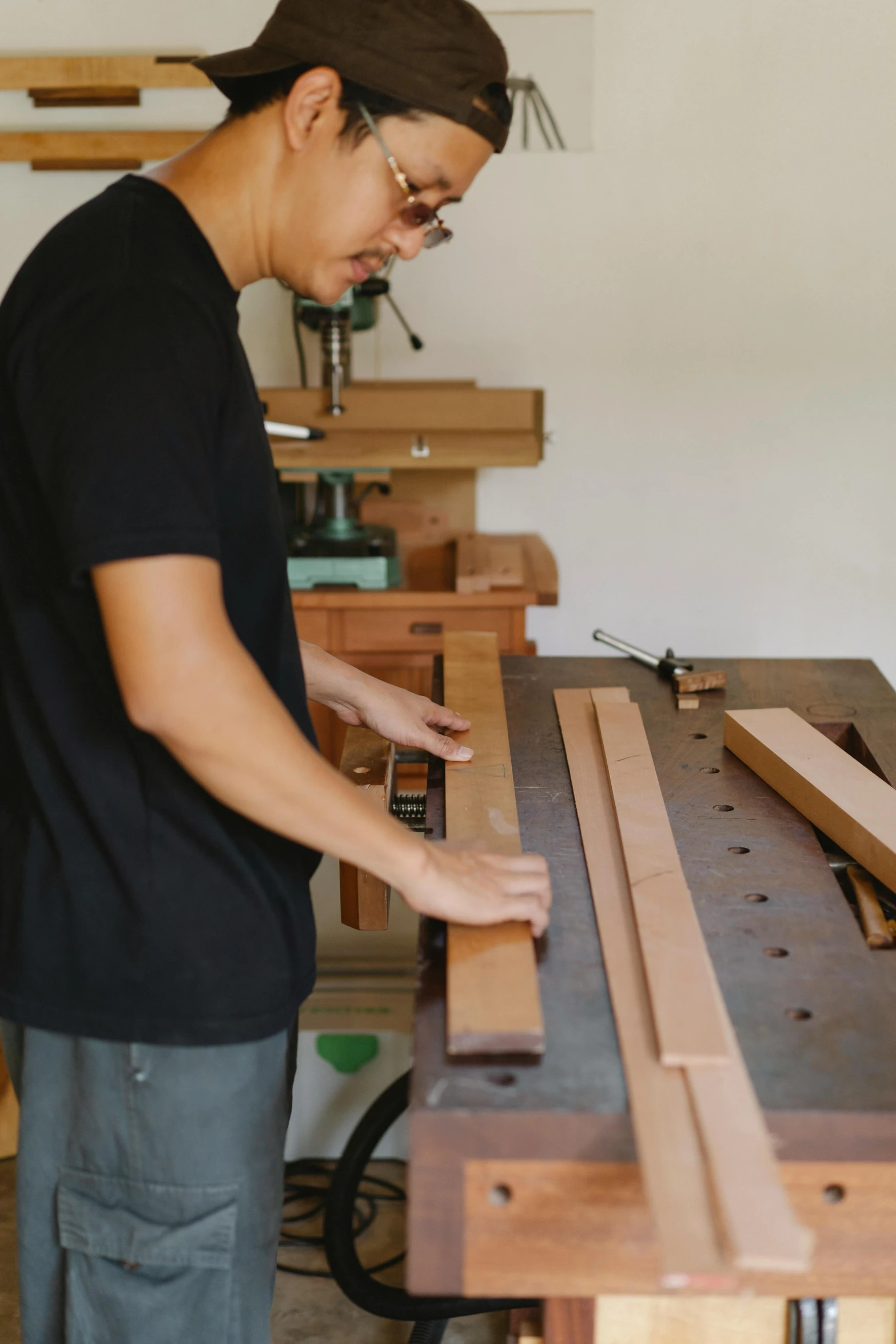 a man that is standing in front of a table, a picture, holding wood saw, profile image, darren quach, benches