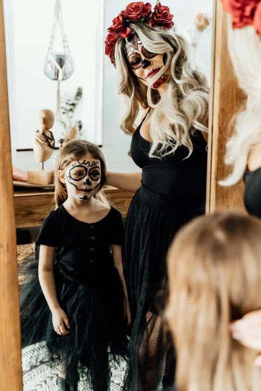 a woman standing in front of a mirror next to a little girl, pexels contest winner, lowbrow, sugar skull, black outfit, a blond, profile image