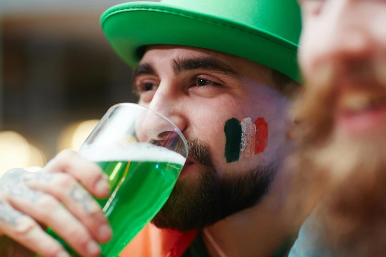 a man in a green hat drinking a beer, a photo, by Adam Marczyński, shutterstock, italian flag, square, college party, 🚿🗝📝