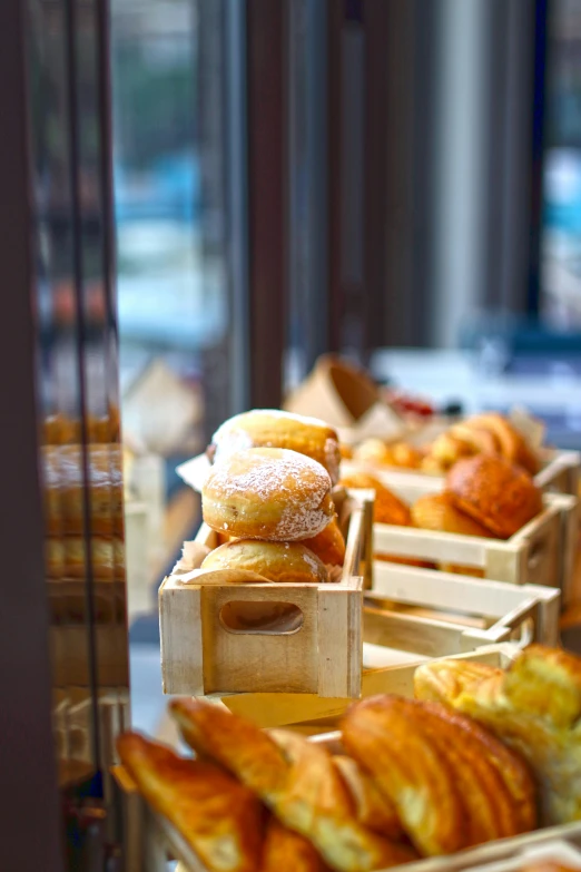 a display case filled with lots of different types of pastries, inspired by Richmond Barthé, unsplash, soft morning light, square, outside, france
