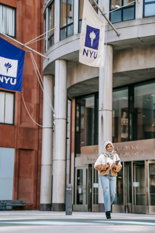 a woman walking down a street past tall buildings, by Nyuju Stumpy Brown, trending on unsplash, wearing a head scarf, at college, banners, ivy