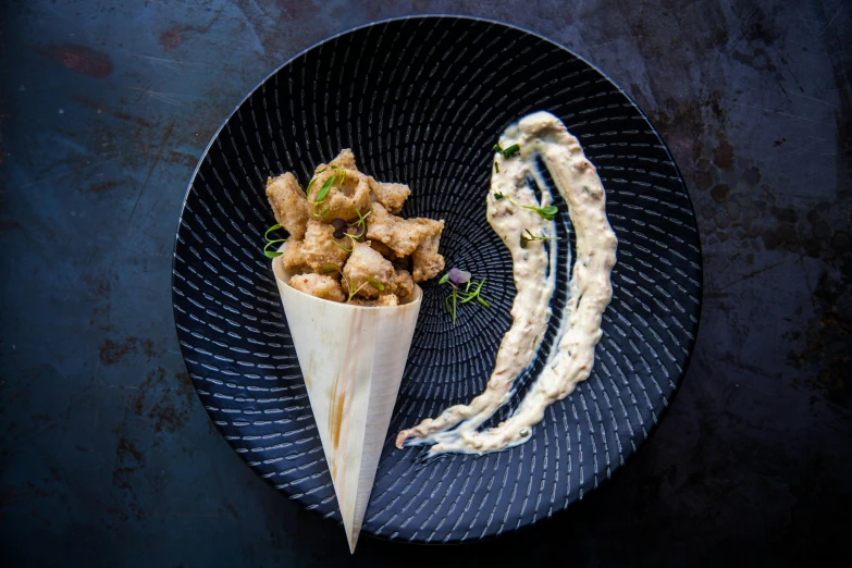 a close up of a plate of food on a table, cone shaped, on a black background, 2 wings, humus