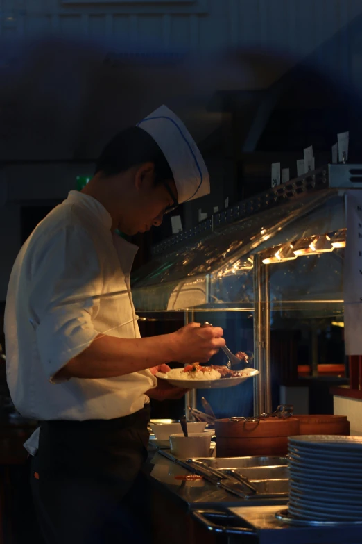 a chef preparing food in a restaurant kitchen, a picture, inspired by Kanō Naizen, side lights, on ship, blue, low quality photo