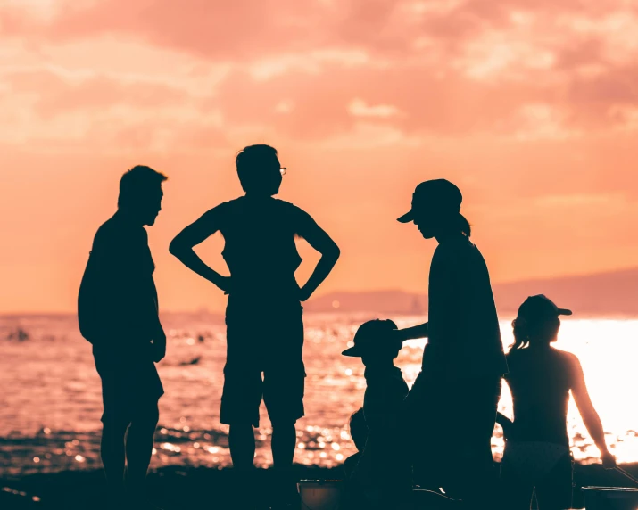 a group of people standing on top of a beach, outlined silhouettes, family friendly, manly, featured