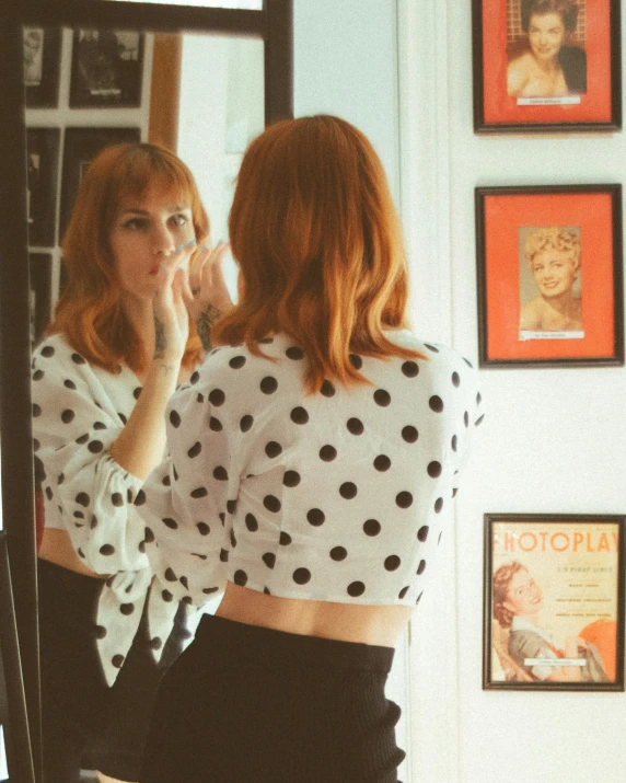 a woman standing in front of a mirror brushing her teeth, an album cover, inspired by Leila Faithfull, pexels contest winner, pop art, ginger hair with freckles, polkadots, outfit photo, view from the back