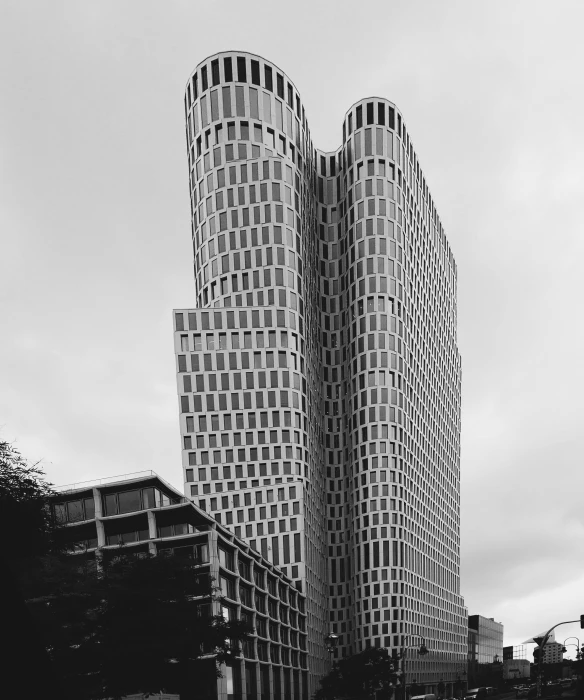 a black and white photo of two tall buildings, inspired by David Chipperfield, curved body, cascading highrise, berlin, yoshikata amano