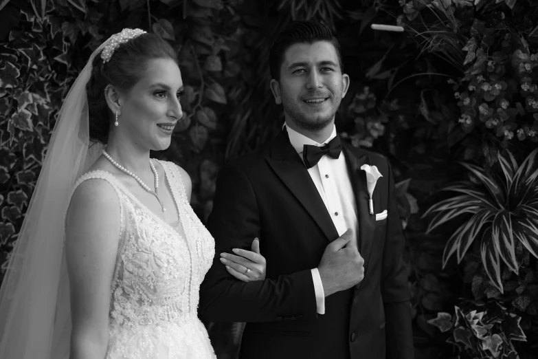 a man in a tuxedo standing next to a woman in a wedding dress, a black and white photo, by Arthur Sarkissian, pexels, ayanamikodon and irakli nadar, alexa grace, portait image, handsome man