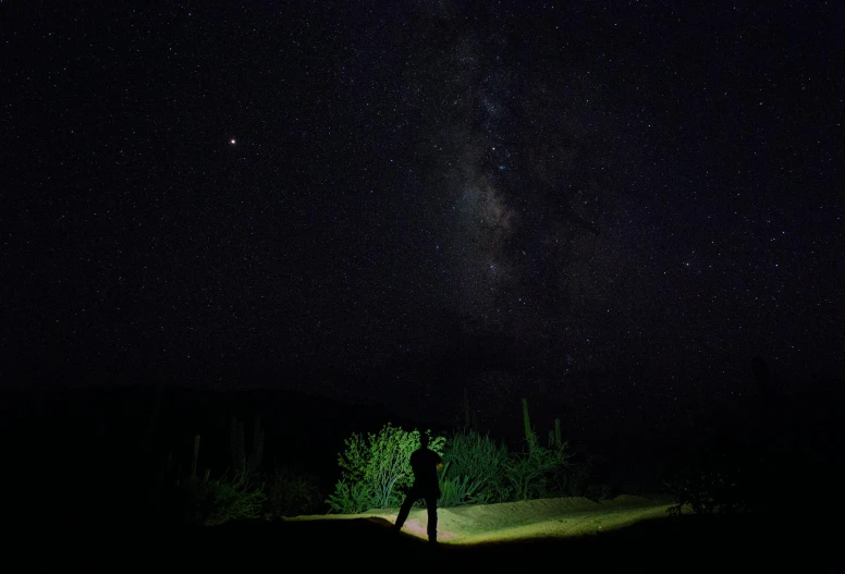 a person standing in the middle of a road at night, mexican desert, stars and planets visible, dark light night, instagram photo