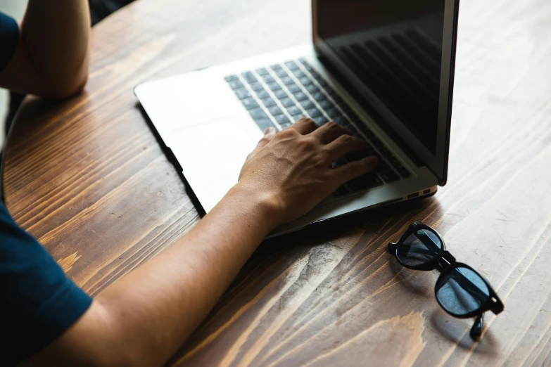 a person using a laptop on a wooden table, by Carey Morris, trending on pexels, avatar image, background image