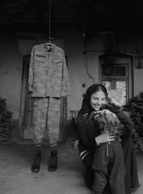 a black and white photo of a woman holding a cat, a black and white photo, by Sohrab Sepehri, girl wearing uniform, bouquet, reza afshar, camouflage made of love