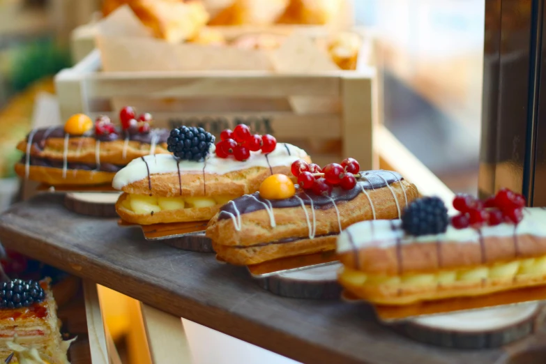 a display case filled with lots of different types of pastries, by Dietmar Damerau, unsplash, romanticism, on a wooden plate, fruit, in a row, molten