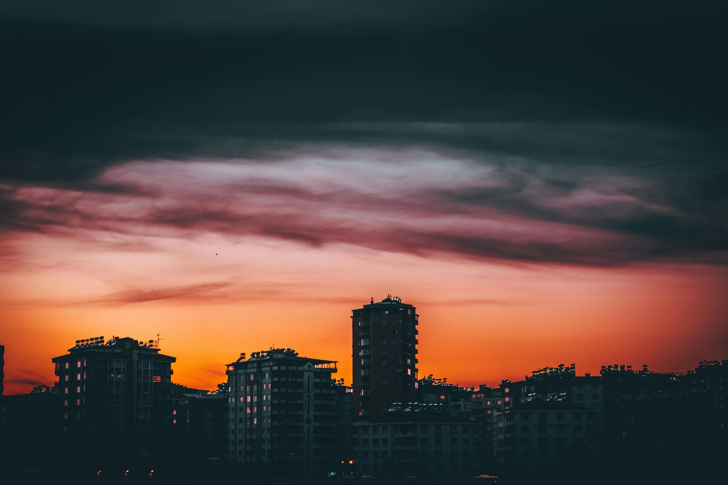 a sunset over a city with tall buildings, inspired by Elsa Bleda, pexels contest winner, dark grey and orange colours, red hues, instagram photo, ominous photo
