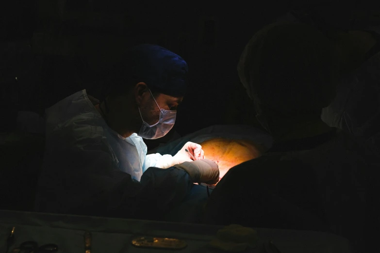 a couple of people that are in the dark, a photo, pexels contest winner, massurrealism, surgery theatre, hatching, people at work, brightly-lit