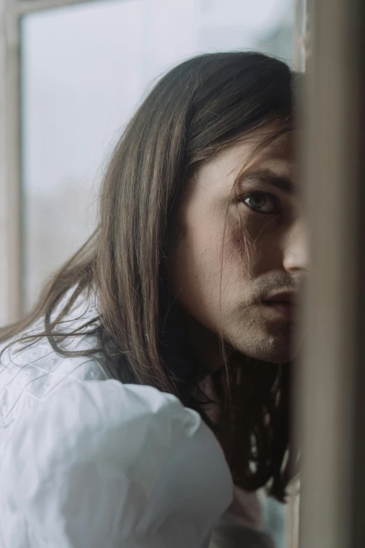 a close up of a person looking out a window, mid long hair, with a hurt expression, leaving a room, music video