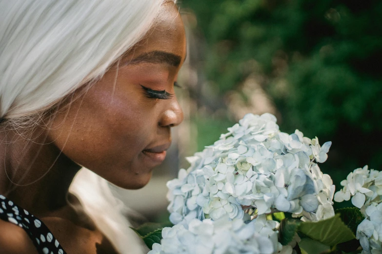 a woman smelling a bunch of white flowers, pexels contest winner, portrait of ororo munroe, profile image, hydrangea, young black woman