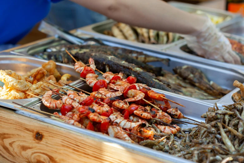 a close up of a tray of food on a table, by Niko Henrichon, fish market stalls, barbecue, avatar image, carnival