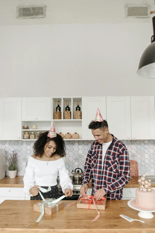 a man and woman cutting a cake in a kitchen, by Carey Morris, pexels contest winner, happening, party hats, panoramic view of girl, curly afro, gif