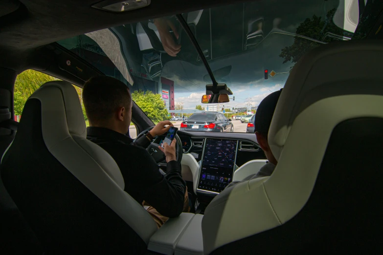 a couple of people that are sitting in a car, tesla, thumbnail, rear facing, performance