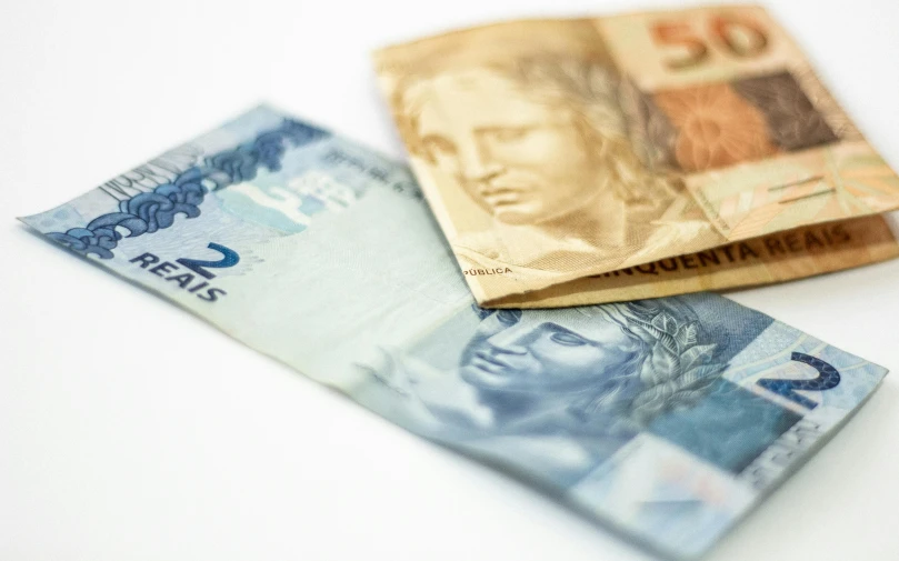 a couple of bills sitting on top of each other, by Amelia Peláez, pexels, brazil, as cristina kirchner, high quality product photo, small details