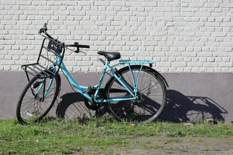 a blue bicycle leaning against a white brick wall, pexels contest winner, realism, background image, high shadow, soviet nostalgia, black and cyan color scheme