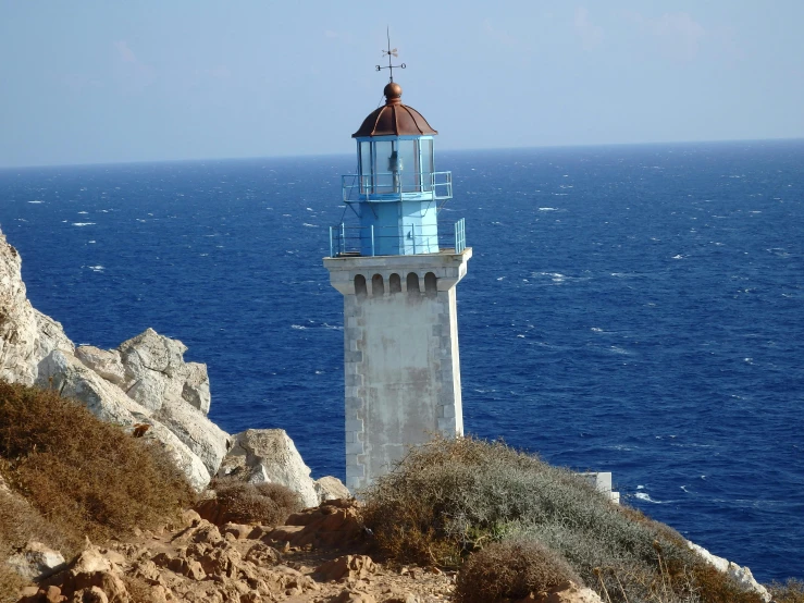 a lighthouse sitting on top of a cliff next to the ocean, pathos, light blue water, square, thumbnail