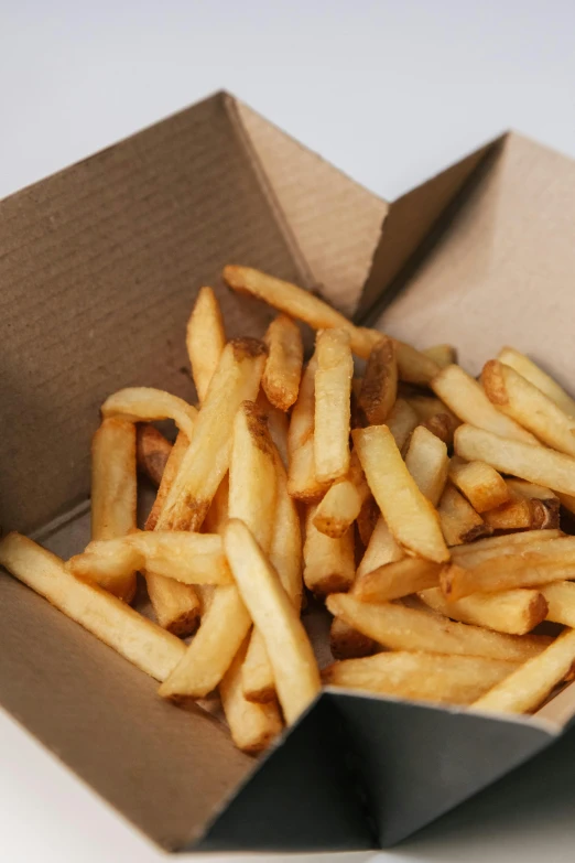 a box of french fries sitting on a table, square lines, traditional medium, up close, small