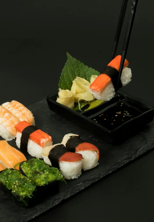 a black plate topped with sushi and chopsticks, dark grey and orange colours, unbeatable quality, medium angle, 王琛