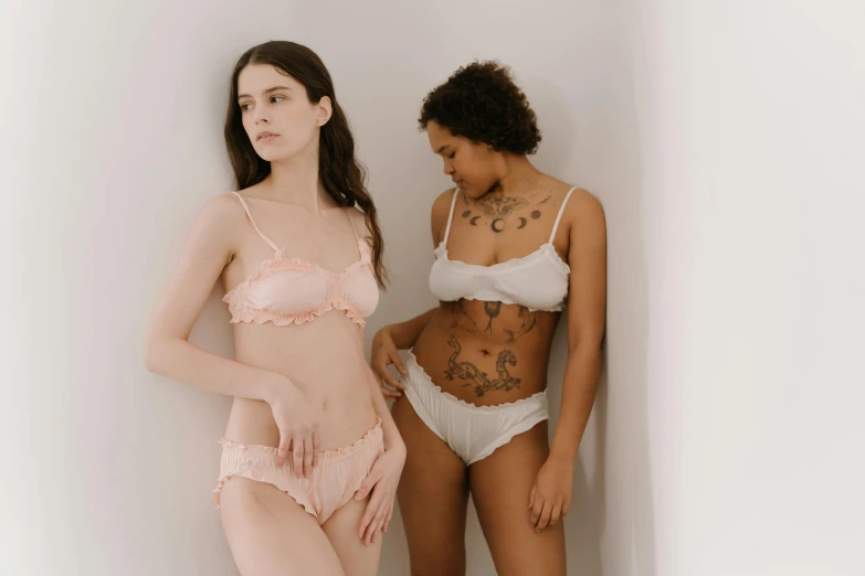 two women in underwear standing next to each other, trending on pexels, extremely pale, varying ethnicities, jovana rikalo, frills