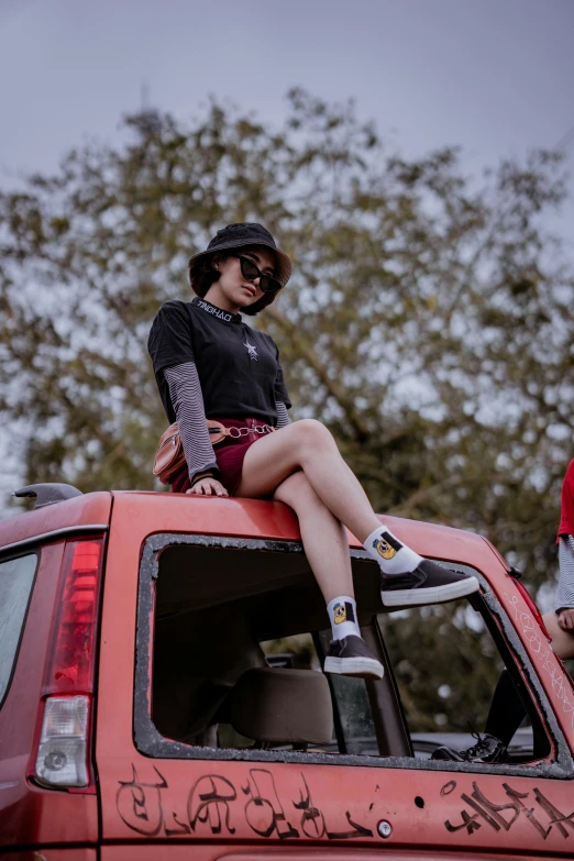 a woman sitting on top of a red truck, pexels contest winner, outlive streetwear collection, te pae, cars and people, sitting on a tree