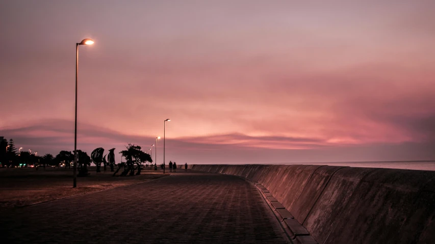 a bench sitting on top of a sidewalk next to the ocean, by Eglon van der Neer, pexels contest winner, pink hues, people walking into the horizon, city wall, curving