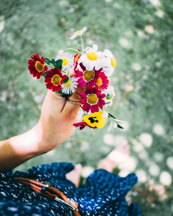 a person holding a bunch of flowers in their hand, by Lucia Peka, trending on unsplash, multi colour, multiple stories, cute photo, made of flowers