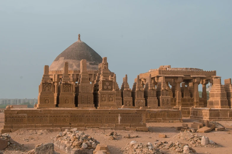 a large stone structure sitting in the middle of a desert, by Joseph Henderson, pexels contest winner, samikshavad, detailed carved ornaments, skyline showing, festivals, mausoleum ruins